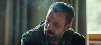 Movie still from “10 Days of a Good Man” (2023), directed by Uluç Bayraktar – A person smoking a cigarette; Close Up shot, Over the shoulder angle