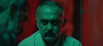 Movie still from “10 Days of a Good Man” (2023), directed by Uluç Bayraktar – A person wearing a white shirt; Close Up shot, Low angle