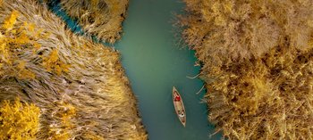 Movie still from “10 Days of a Good Man” (2023), directed by Uluç Bayraktar – An aerial view of a boat in the water; Extreme Wide shot, Overhead angle
