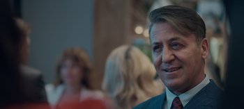 Movie still from “10 Days of a Good Man” (2023), directed by Uluç Bayraktar – A person wearing a suit and tie; Close Up shot, Over the shoulder angle