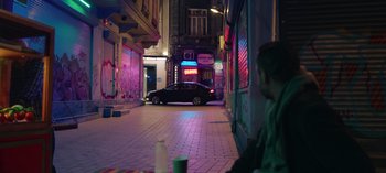 Movie still from “10 Days of a Good Man” (2023), directed by Uluç Bayraktar – A car is parked in the middle of the street; Wide shot, High angle