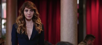 Movie still from “10 Days of a Good Man” (2023), directed by Uluç Bayraktar – A woman with long red hair wearing a black suit; Close Up shot, Over the shoulder angle