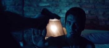 Movie still from “10 Days of a Good Man” (2023), directed by Uluç Bayraktar – A man is pointing a gun at the camera; Close Up shot, Over the shoulder angle