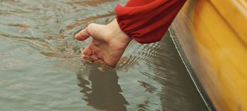 Movie still from “10 Days of a Good Man” (2023), directed by Uluç Bayraktar – A hand is reaching out of a body of water; Extreme Close Up shot, High angle