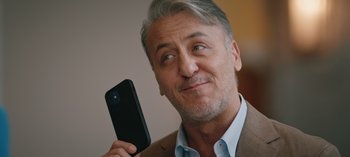 Movie still from “10 Days of a Good Man” (2023), directed by Uluç Bayraktar – A person holding a cell phone; Close Up shot, Over the shoulder angle