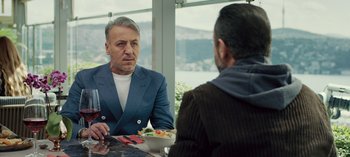 Movie still from “10 Days of a Good Man” (2023), directed by Uluç Bayraktar – A man sitting at a table with a bowl of food; Medium shot, Over the shoulder angle