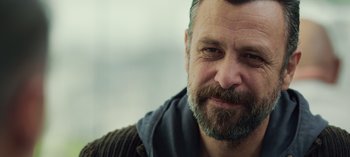 Movie still from “10 Days of a Good Man” (2023), directed by Uluç Bayraktar – A person with a beard; Close Up shot, Over the shoulder angle