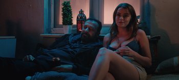 Movie still from “10 Days of a Good Man” (2023), directed by Uluç Bayraktar – A man and a woman sitting on a couch; Medium shot, Over the shoulder angle