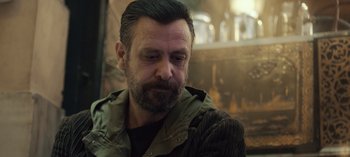 Movie still from “10 Days of a Good Man” (2023), directed by Uluç Bayraktar – A person with a beard; Close Up shot, Over the shoulder angle