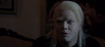 Movie still from “10 Days of a Good Man” (2023), directed by Uluç Bayraktar – A man with white hair and a black shirt; Close Up shot, Over the shoulder angle