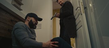 Movie still from “10 Days of a Good Man” (2023), directed by Uluç Bayraktar – A man holding a gun and another man holding a knife; Medium shot, High angle