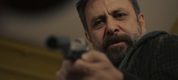 Movie still from “10 Days of a Good Man” (2023), directed by Uluç Bayraktar – A person holding a gun; Close Up shot, Over the shoulder angle