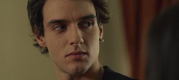 Movie still from “10 Days of a Good Man” (2023), directed by Uluç Bayraktar – A person wearing a black shirt; Close Up shot, Over the shoulder angle