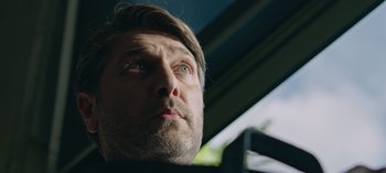 Movie still from “10 Days of a Good Man” (2023), directed by Uluç Bayraktar – A person looking up at the sky; Close Up shot, Low angle