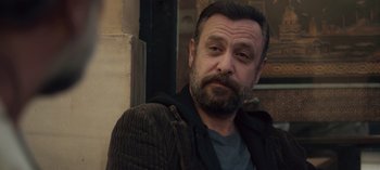 Movie still from “10 Days of a Good Man” (2023), directed by Uluç Bayraktar – A person with a beard; Close Up shot, Over the shoulder angle