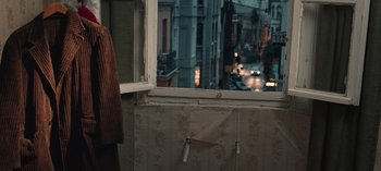 Movie still from “10 Days of a Good Man” (2023), directed by Uluç Bayraktar – A view of a city from an open window of an apartment; Medium shot, High angle