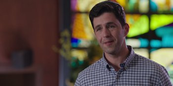 Movie still from “13: The Musical” (2022), directed by Tamra Davis – A man in a plaid shirt is looking at the camera; Close Up shot, Over the shoulder angle