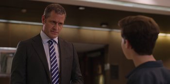 Movie still from “13: The Musical” (2022), directed by Tamra Davis – A man in a suit and tie standing next to another man; Close Up shot, Over the shoulder angle