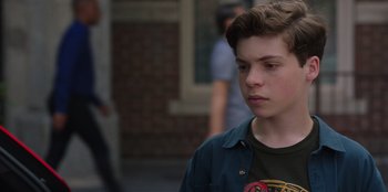 Movie still from “13: The Musical” (2022), directed by Tamra Davis – A young man is standing in the street; Close Up shot, Over the shoulder angle
