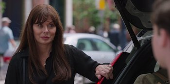 Movie still from “13: The Musical” (2022), directed by Tamra Davis – A woman standing next to a red car; Close Up shot, Over the shoulder angle