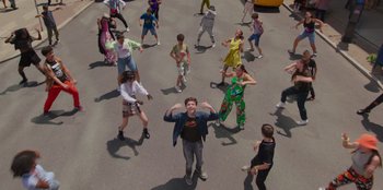 Movie still from “13: The Musical” (2022), directed by Tamra Davis – A group of young people standing in the middle of the street; Wide shot, Overhead angle