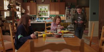 Movie still from “13: The Musical” (2022), directed by Tamra Davis – A group of people sitting at a table eating breakfast; Wide shot, Over the shoulder angle
