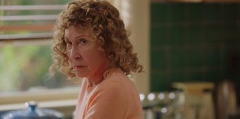 Movie still from “13: The Musical” (2022), directed by Tamra Davis – A person with curly blonde hair; Close Up shot, Over the shoulder angle