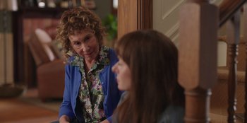 Movie still from “13: The Musical” (2022), directed by Tamra Davis – A woman sitting next to another woman in front of a door; Close Up shot, Over the shoulder angle
