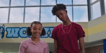 Movie still from “13: The Musical” (2022), directed by Tamra Davis – A couple of kids standing next to each other in a room; Medium shot, Low angle