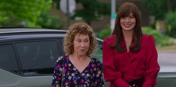 Movie still from “13: The Musical” (2022), directed by Tamra Davis – Two women are standing next to each other on the street; Medium shot, Over the shoulder angle
