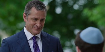 Movie still from “13: The Musical” (2022), directed by Tamra Davis – A person wearing a suit and tie; Close Up shot, Over the shoulder angle