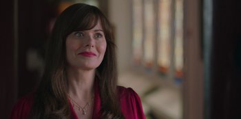 Movie still from “13: The Musical” (2022), directed by Tamra Davis – A person with long hair wearing a necklace; Close Up shot, Over the shoulder angle
