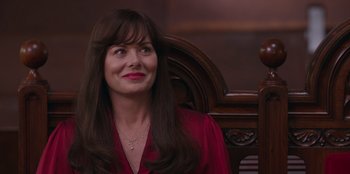 Movie still from “13: The Musical” (2022), directed by Tamra Davis – A woman in a red shirt sitting in a chair; Close Up shot, Over the shoulder angle