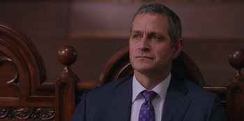 Movie still from “13: The Musical” (2022), directed by Tamra Davis – A person wearing a suit and tie; Close Up shot, Over the shoulder angle