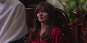 Movie still from “13: The Musical” (2022), directed by Tamra Davis – A woman sitting in a chair wearing a red shirt; Close Up shot, Over the shoulder angle