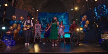 Movie still from “13: The Musical” (2022), directed by Tamra Davis – A group of young people on a stage singing a song; Wide shot, Low angle