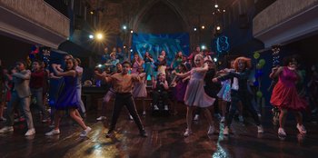 Movie still from “13: The Musical” (2022), directed by Tamra Davis – A group of young people dancing in a room; Wide shot, High angle