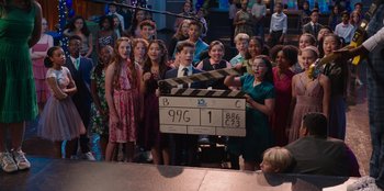 Movie still from “13: The Musical” (2022), directed by Tamra Davis – A group of people standing in front of a camera; Extreme Wide shot, High angle
