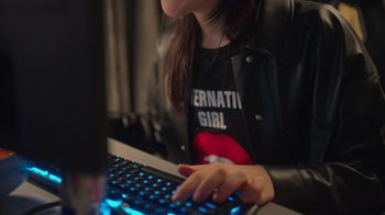 Movie still from “1UP” (2022), directed by Kyle Newman – A woman is typing on a computer keyboard; Close Up shot, High angle