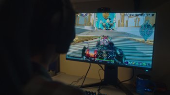 Movie still from “1UP” (2022), directed by Kyle Newman – A person sitting in front of a computer monitor; Extreme Close Up shot, High angle