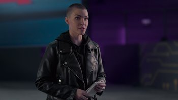 A woman in a leather jacket holding a cell phone in her hand
