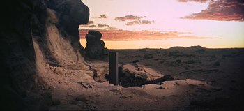 Movie still from “2001: A Space Odyssey” (1968), directed by Stanley Kubrick – A view of a desert landscape with rocks and a sky background; Extreme Wide shot, Low angle
