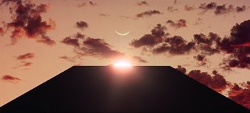 Movie still from “2001: A Space Odyssey” (1968), directed by Stanley Kubrick – The sun is setting in the sky with a crescent moon in the background; Extreme Wide shot, Low angle