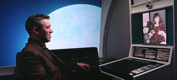 Movie still from “2001: A Space Odyssey” (1968), directed by Stanley Kubrick – A man sitting in front of a large window; Medium shot, Over the shoulder angle