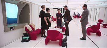 Movie still from “2001: A Space Odyssey” (1968), directed by Stanley Kubrick – A group of people standing around a room; Wide shot, Over the shoulder angle