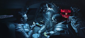 Movie still from “2001: A Space Odyssey” (1968), directed by Stanley Kubrick – A group of people in space suits are eating bananas; Medium shot, Overhead angle
