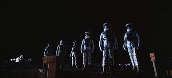 Movie still from “2001: A Space Odyssey” (1968), directed by Stanley Kubrick – A group of people in spacesuits standing in the dark; Wide shot, Low angle