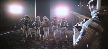 Movie still from “2001: A Space Odyssey” (1968), directed by Stanley Kubrick – A group of people in spacesuits standing in the dirt; Wide shot, Low angle