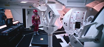 Movie still from “2001: A Space Odyssey” (1968), directed by Stanley Kubrick – A man in a space suit standing in a room; Wide shot, Overhead angle