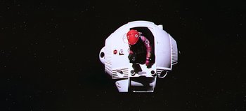 Movie still from “2001: A Space Odyssey” (1968), directed by Stanley Kubrick – A person in a space suit is sitting on a space ship; Extreme Wide shot, Overhead angle